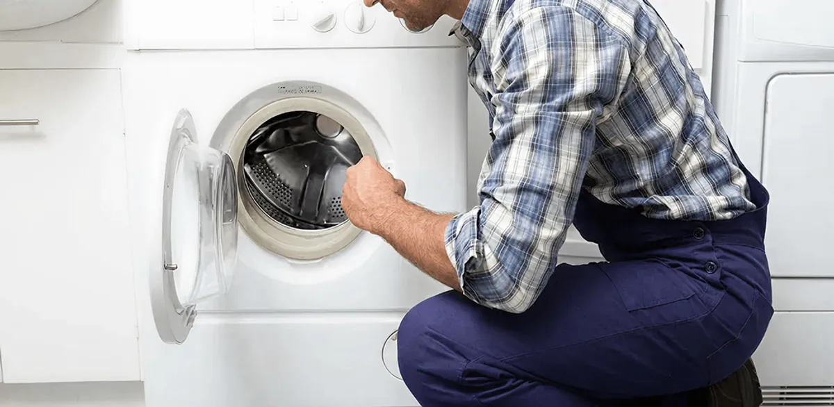 Handyman inspecting a dryer drum and internal parts for repair in Anchorage, AK