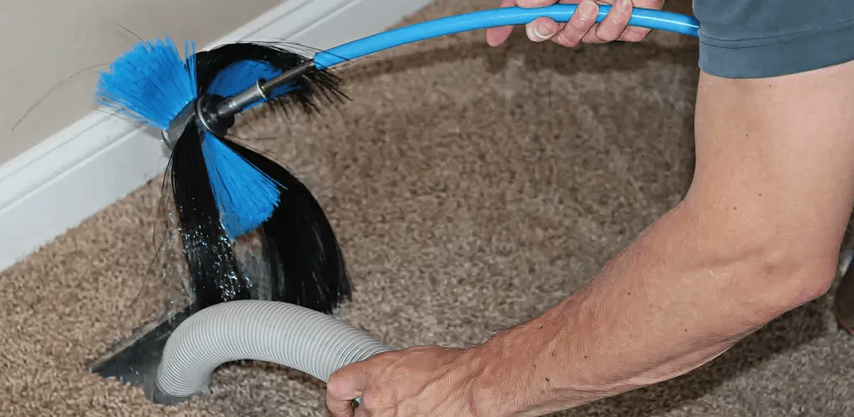 Dryer vent cleaning technician brushing lint from a vent line in Anchorage, AK